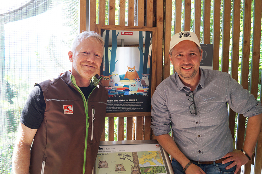 Mag. Stephan Bair (Tyrolia-Vorstand Handel) und Alpenzoo-Direktor Dr. André Stadler bei der Enthüllung des Spiegels beim Uhu-Gehege im Alpenzoo Innsbruck | © Tyrolia
